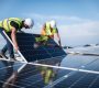 Two men on a roof, installing a solar panel