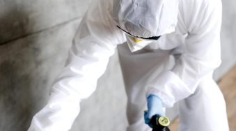 full-shot-man-with-suit-disinfecting-stairs