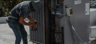 HVAC heating and cooling technician working on HVAC unit