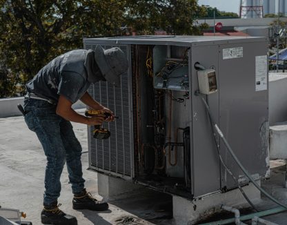 HVAC heating and cooling technician working on HVAC unit