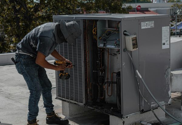 HVAC heating and cooling technician working on HVAC unit