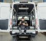 Technician sitting in maintenance HVAC plumbing van using a mobile tablet.